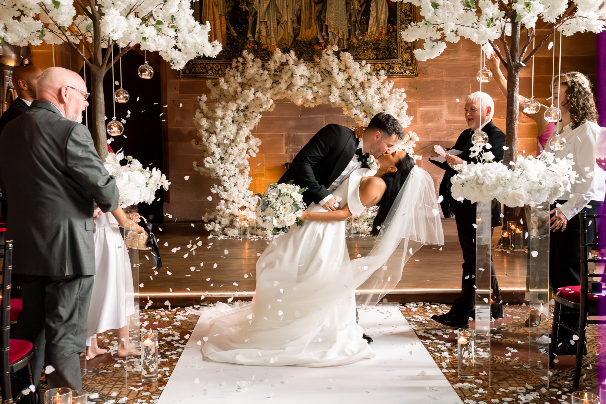 bride and groom do a dip kiss as they walk back up the aisle at Peckforton Castle 