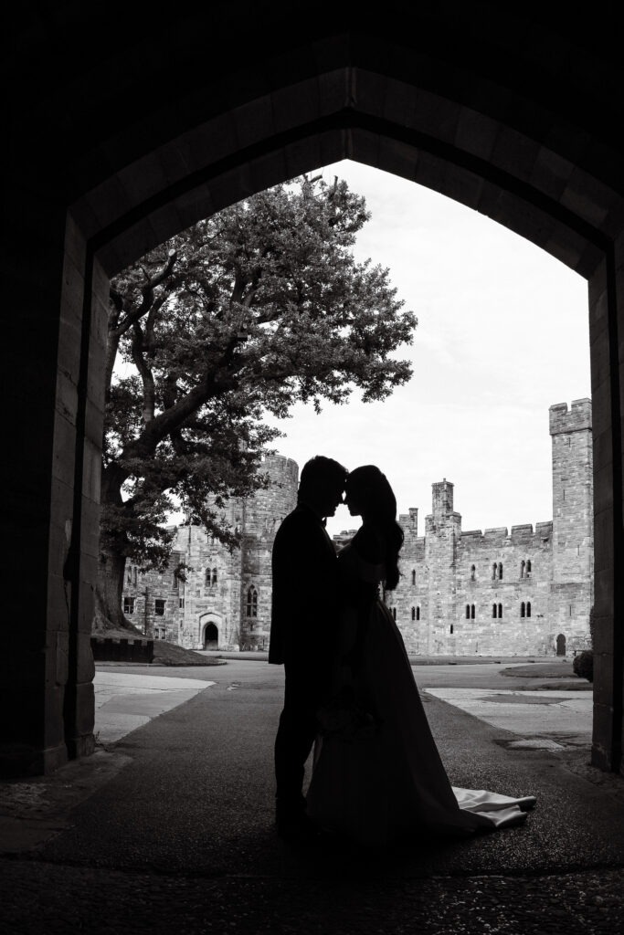 silhouette of couple with castle behind them